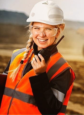 woman using two-way radio on a mine site
